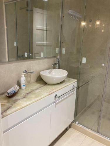 une salle de bain avec un lavabo et une douche en verre dans l'établissement Ventana al mar, à Mar del Plata