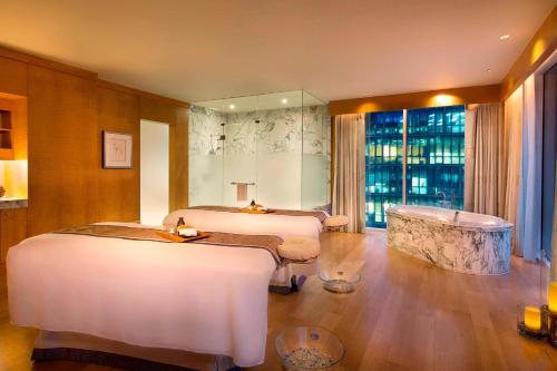 a hotel room with two beds and a tub at Ritz Carlton DIFC Downtown Dubai in Dubai