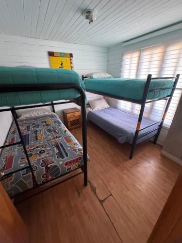 two bunk beds in a room with a wooden floor at ripamontilodge in Coquimbo