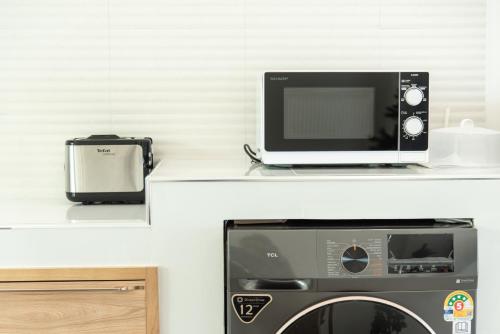a microwave oven sitting on a shelf next to a toaster at Turtle Tales-Mafueang,Turtle Beach,Phang-Nga in Phang-nga