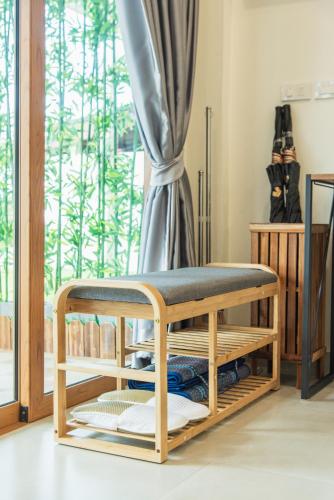 a wooden bench in a room with a window at Turtle Tales-Mafueang,Turtle Beach,Phang-Nga in Phang-nga