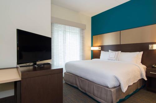 a hotel room with a bed and a flat screen tv at Residence Inn Raleigh-Durham Airport/Brier Creek in Raleigh