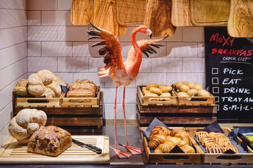 a store display of bread and a flaming bird in a bakery at Moxy Poznań Airport in Poznań