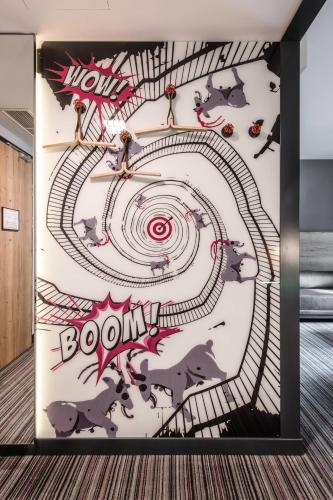 a wall with a painting of a roller coaster at Moxy Poznań Airport in Poznań