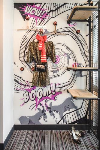 a wall with a mural of a woman in a coat at Moxy Poznań Airport in Poznań