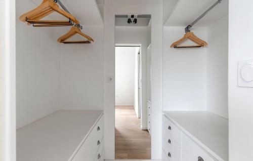 un couloir blanc avec des armoires blanches et des cintres en bois dans l'établissement Angel, à Lagny-sur-Marne