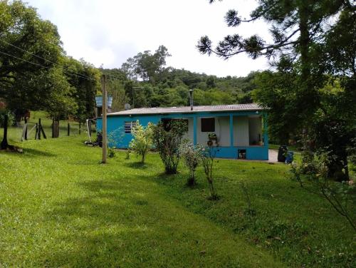 una casa blu in mezzo a un campo di Sitio dos pinhais a Pelotas