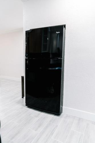 a black refrigerator sitting in the corner of a room at Welcome to 305 Rentals in Miami Gardens