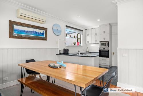 a kitchen with a wooden table and a counter top at Island Escape with 12m Indoor Pool in Surf Beach