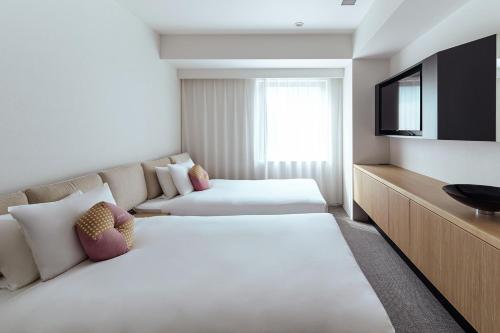 a hotel room with two beds and a flat screen tv at OMO3 Tokyo Akasaka by Hoshino Resort in Tokyo