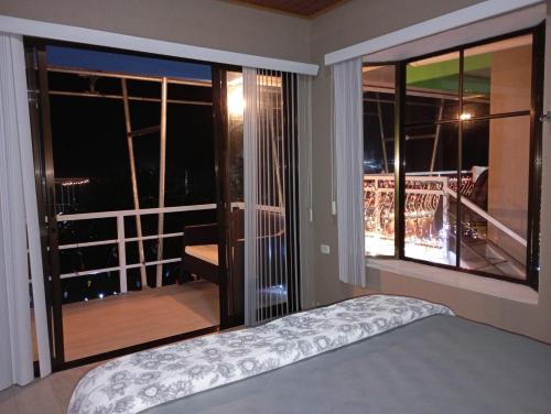 a bedroom with a bed and a view of a balcony at Villas Lux Arenal in Fortuna