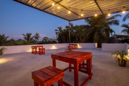 a patio with benches and a table and lights at Blueray Villa in Unawatuna