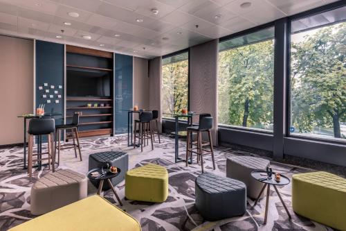 a lobby with tables and chairs and large windows at Zurich Marriott Hotel in Zürich