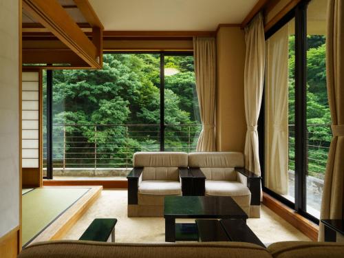 a living room with a couch and a table and a large window at Hotel Ogawa in Asahi