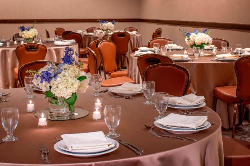 a conference room with tables and chairs with flowers on them at Sheraton Houston Brookhollow Hotel in Houston