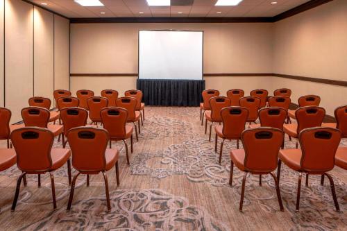 an empty room with orange chairs and a screen at Sheraton Houston Brookhollow Hotel in Houston