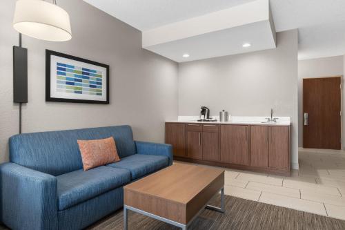 ein Wohnzimmer mit einem blauen Sofa und einem Tisch in der Unterkunft Holiday Inn Express Hotel & Suites Coralville by IHG in Coralville