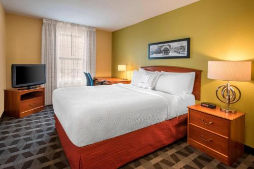 a hotel room with a bed and a television at Ville 7877 in Centennial