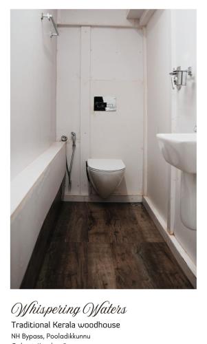 a bathroom with a toilet and a sink at whispering waters in Kozhikode