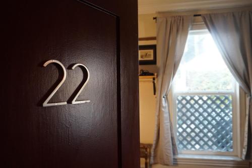 a door with a number on it next to a window at The Rosemary in Los Angeles