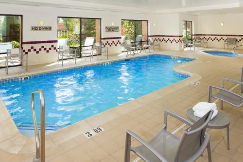 a large pool in a hotel with chairs and tables at SpringHill Suites by Marriott Portland Hillsboro in Hillsboro
