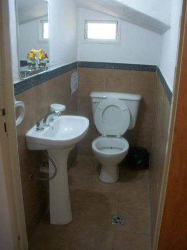 a bathroom with a white toilet and a sink at Cabañas Cuñas del Trapiche in Trapiche