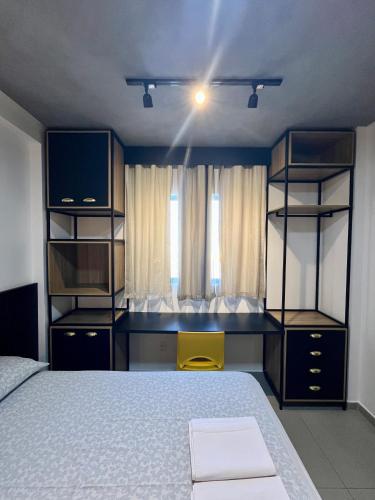 a bedroom with a bed and shelves and a window at Studio Estilo Industrial 03 in Mossoró