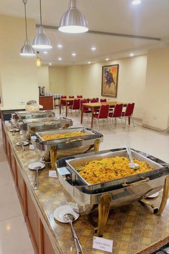 a buffet line with many trays of food on it at Sultan Hotel Banda Aceh in Banda Aceh