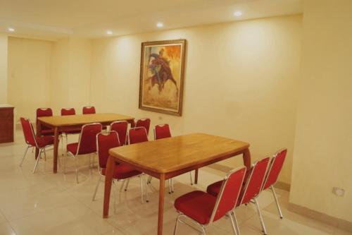 a conference room with two tables and red chairs at Sultan Hotel Banda Aceh in Banda Aceh