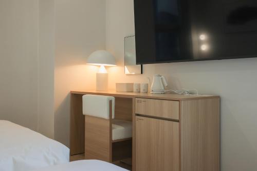 a room with a desk with a bed and a lamp at Aank Hotel Sejong in Sejong