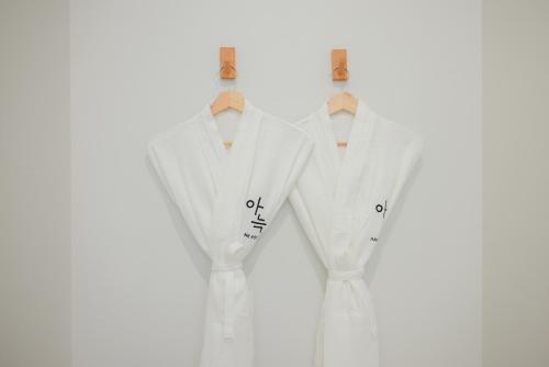 two white suits on mannequins against a white background at Aank Hotel Sejong in Sejong