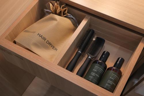 a wooden shelf with hair brushes and a bag at Aank Hotel Sejong in Sejong
