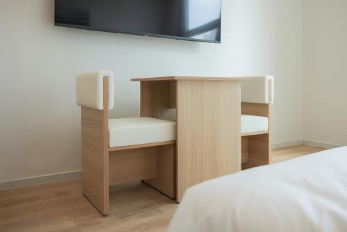a bed room with a desk and a tv on a wall at Aank Hotel Sejong in Sejong