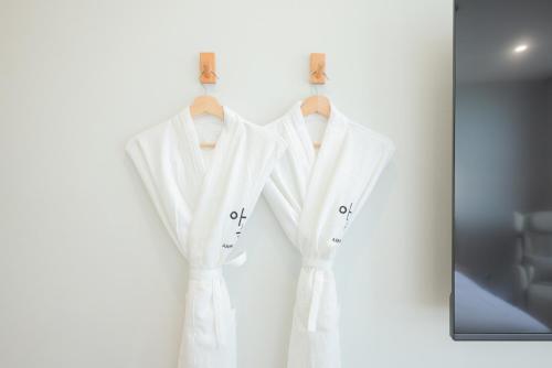 a couple of white shirts hanging on a wall at Aank Hotel Sejong in Sejong