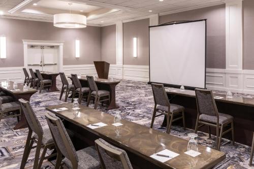 a conference room with tables and chairs and a screen at Sheraton Ann Arbor Hotel in Ann Arbor