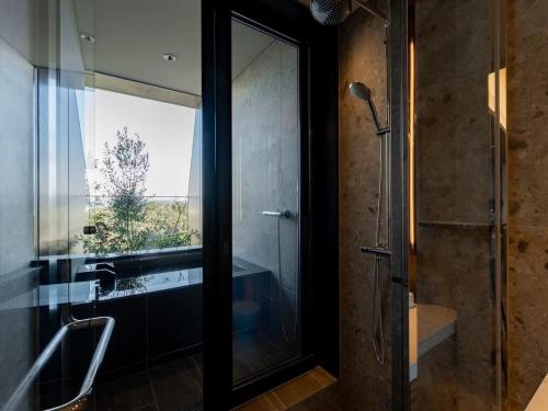 a bathroom with a shower and a glass door at GREENITY IWATA in Iwata