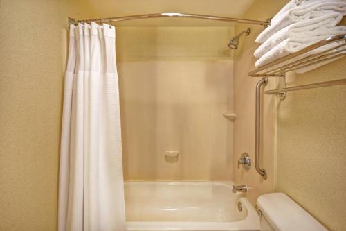 a bathroom with a shower and a white shower curtain at SpringHill Suites by Marriott Baltimore BWI Airport in Linthicum Heights
