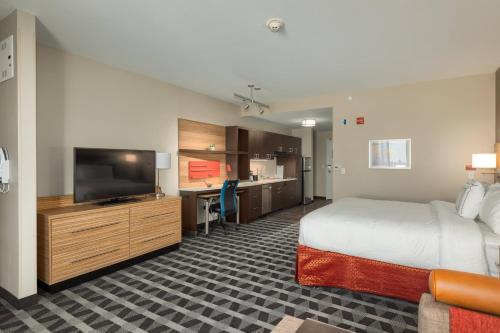a hotel room with a bed and a flat screen tv at TownePlace Suites by Marriott Owensboro in Owensboro