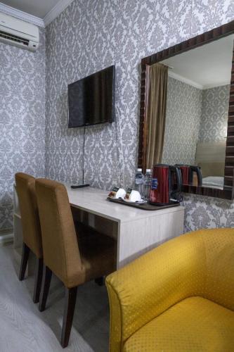 a room with a table with chairs and a mirror at Алматы Транзит №1 in Turksib
