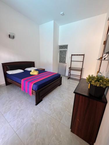 a bedroom with a bed and a chair at Grand Royal Villa Negombo in Negombo