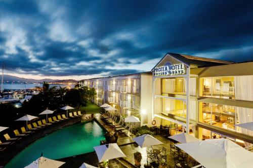a view of a hotel with a pool at night at Protea Hotel by Marriott Knysna Quays in Knysna
