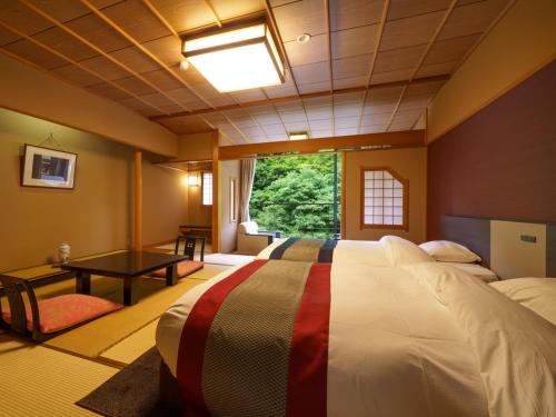 a bedroom with a large bed and a window at Hotel Ogawa in Asahi