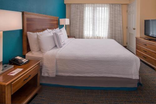 a hotel room with a bed and a television at Residence Inn by Marriott Chesapeake Greenbrier in Chesapeake