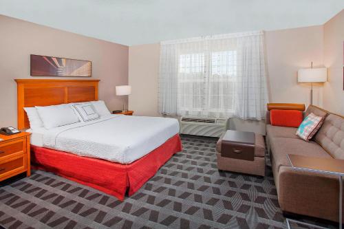 ノックスビルにあるTownePlace Suites Knoxville Cedar Bluffのベッドとソファのあるホテルの部屋