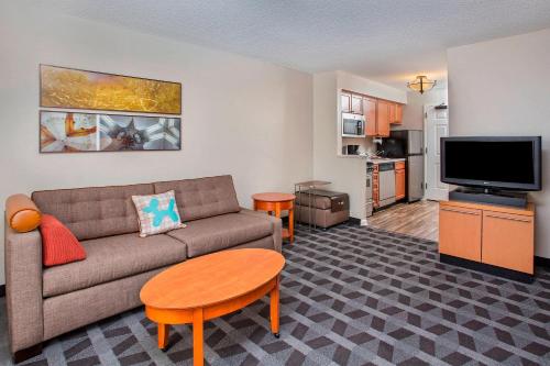 a living room with a couch and a flat screen tv at TownePlace Suites Knoxville Cedar Bluff in Knoxville