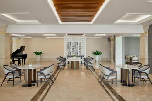 a room with tables and chairs and a piano at Danang Marriott Resort & Spa in Danang