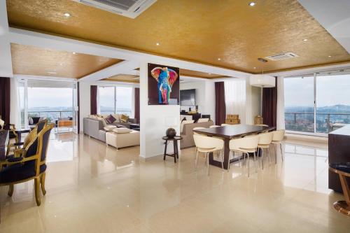 a dining room and living room with a table and chairs at Protea Hotel by Marriott Kampala Skyz in Kampala