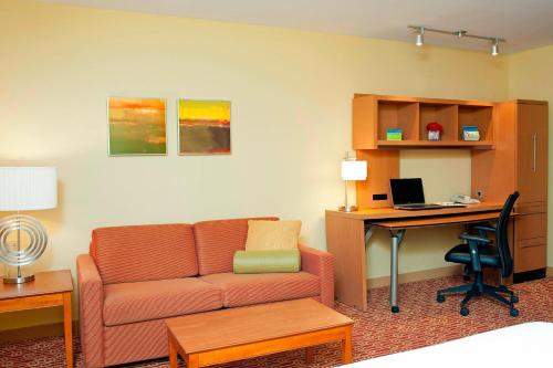 a living room with a couch and a desk with a computer at TownePlace Suites by Marriott Bloomington in Bloomington