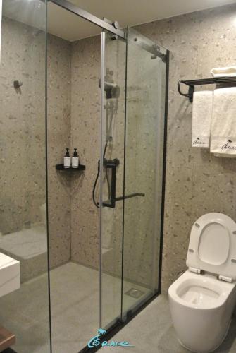 a bathroom with a glass shower with a toilet at Grace Hotel in Honiara