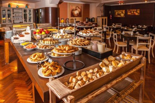 a long table with many plates of food on it at Sheraton Bariloche Hotel in San Carlos de Bariloche